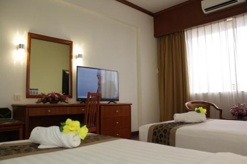 Uma cama ou camas num quarto em Hotel Sandakan