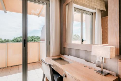 a home office with a desk and a window at Hotel Europa Lignano in Lignano Sabbiadoro