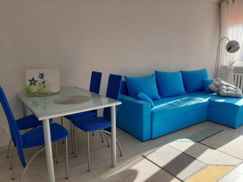 a living room with a blue couch and a table at Apartament w Lądku Zdroju przy Rynku in Lądek-Zdrój