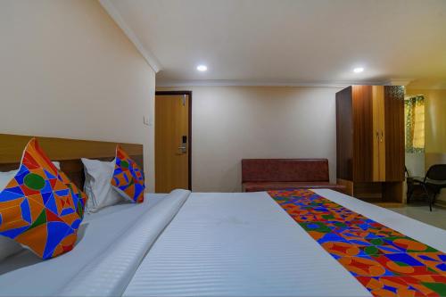 a bedroom with a large bed with a colorful blanket at FabHotel Pishori in Indore