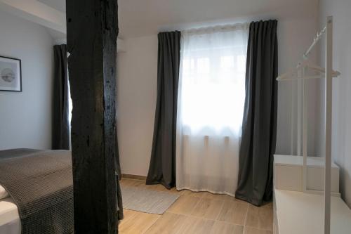 a bedroom with a bed and a large window at Weberhof Ferienapartments in Rostrup am Westufer des Zwischenahner Meers in Bad Zwischenahn