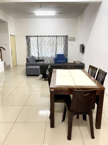 a living room with a table and chairs and a couch at Azzalea Homes 2 @ Taman Golden Hills Cameron Highlands in Cameron Highlands