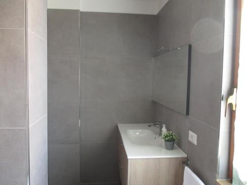 y baño con lavabo y espejo. en Anagnina Apartment Capistrano en Roma