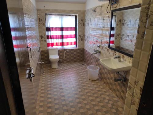 łazienka z toaletą, umywalką i oknem w obiekcie Premier Inn w mieście Yercaud