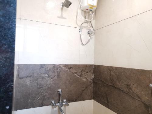 a shower in a bathroom with a shower head at Mahalaxmi Executive in Kolhapur