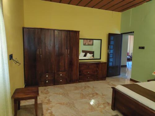 a bedroom with a large wooden cabinet and a mirror at Premier Inn in Yercaud