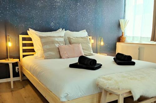 a bed with two black hats on top of it at NOUVEAU*Le Bois étoilé*Balnéo*Massage*Détente*Wifi*Netflix*Self-checkin in Venette