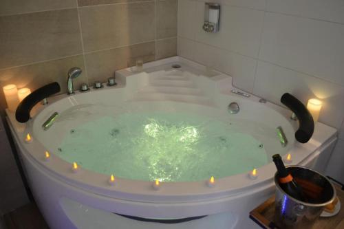 a bath tub with lights in it with a candle at NOUVEAU*Le Bois étoilé*Balnéo*Massage*Détente*Wifi*Netflix*Self-checkin in Venette