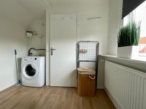 a laundry room with a washing machine and a window at T-Rots, prachtig zomerhuis in Noordwijk aan Zee