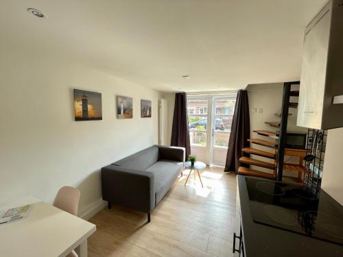 a living room with a couch and a table at T-Rots, prachtig zomerhuis in Noordwijk aan Zee