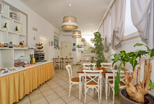 a restaurant with tables and chairs and a kitchen at City Hotel in Viareggio