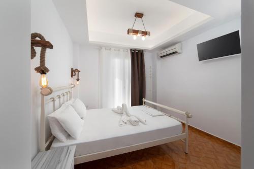 a bedroom with a white bed with white pillows at Blue Waves View in Batsi