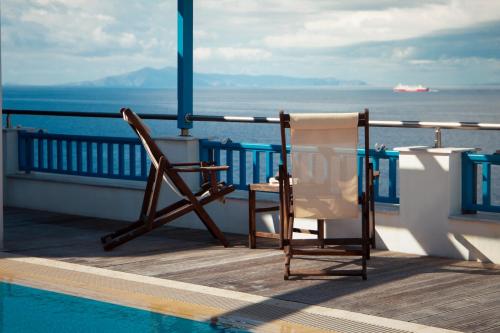 a chair sitting on a balcony next to a swimming pool at Blue Waves View in Batsi