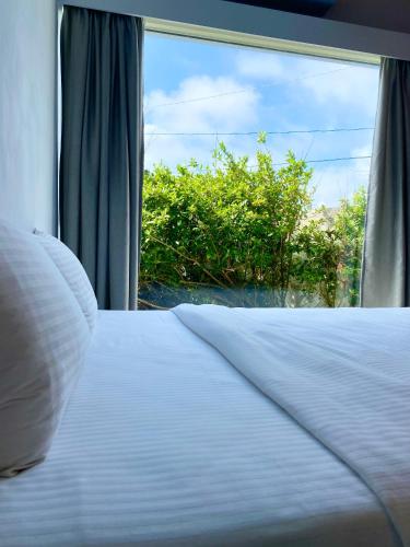 a bed in a room with a window at 墾丁花見小院Villa包棟民宿 in Eluan