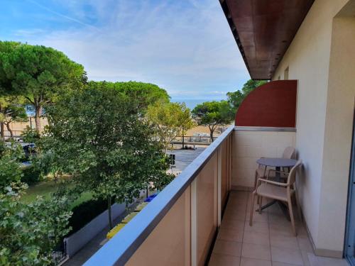a balcony with a table and trees on a building at Hotel Europa Lignano in Lignano Sabbiadoro