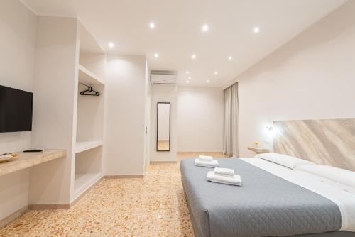 Un dormitorio blanco con una cama grande y un televisor de pantalla plana. en Ancient Rome Room, en Roma