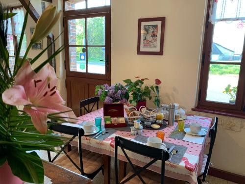 een eetkamer met een tafel met een roze tafelkleed bij Les Logis du Breuil in Marchéville