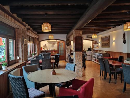 a restaurant with tables and chairs and a kitchen at Hotel Cap d'Or in Tossa de Mar