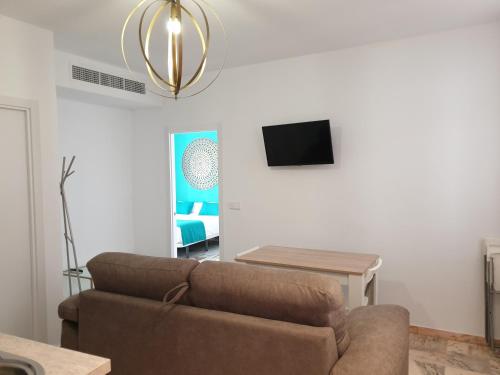 
a living room filled with furniture and a tv at Hotel y Apartamentos Doña Lola in Seville
