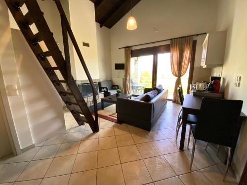 a living room with a couch and a staircase at Lithos Villas in Amfikleia