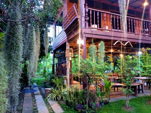 a house with a balcony and a garden at Metha Country View Homestay Singburi in Ban Kho Sai