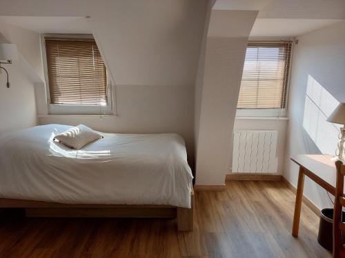 ein kleines Schlafzimmer mit einem Bett und zwei Fenstern in der Unterkunft Logis hôtel le relais de l'abbaye in Saint-Évroult-Notre-Dame-du-Bois