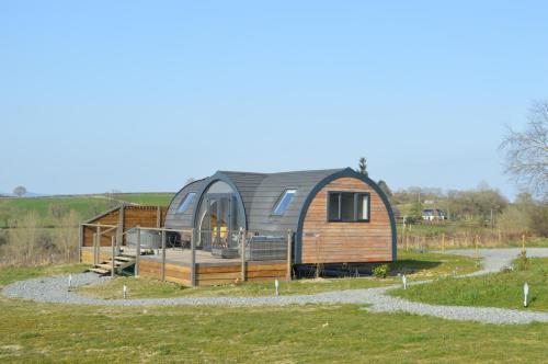 ein kreisförmiges Haus mit einem Metalldach auf einem Grasfeld in der Unterkunft Saddle Hill Lodge in Broome