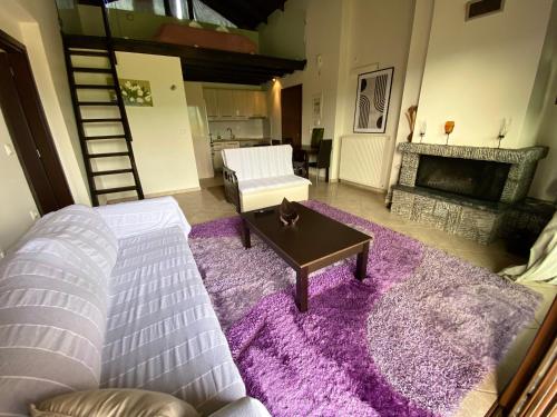 a living room with a couch and a fireplace at Lithos Villas in Amfiklia