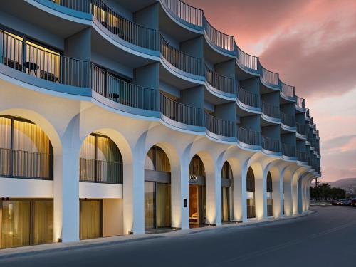 an external view of a building with arches at NIKO Seaside Resort MGallery in Agios Nikolaos