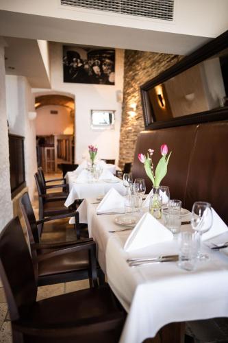 a row of tables in a restaurant with white table settings at Seehotel Luitpold in Tegernsee