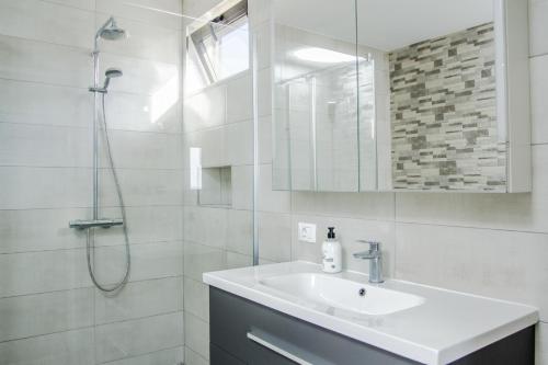 y baño blanco con lavabo y ducha. en The Tree House Tenerife, en El Médano
