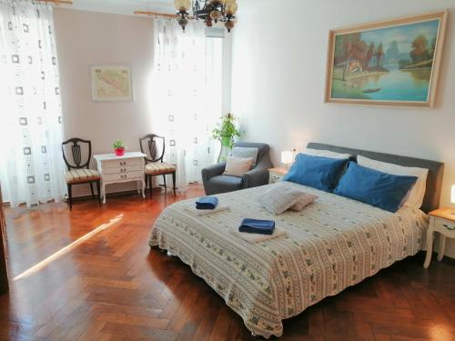 1 dormitorio con 1 cama grande con almohadas azules en Guest House Barocco, en Rovinj