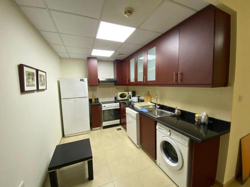 a kitchen with a white refrigerator and a dishwasher at 1 Bedroom in Jumeirah Beach Residence Dubai in Dubai