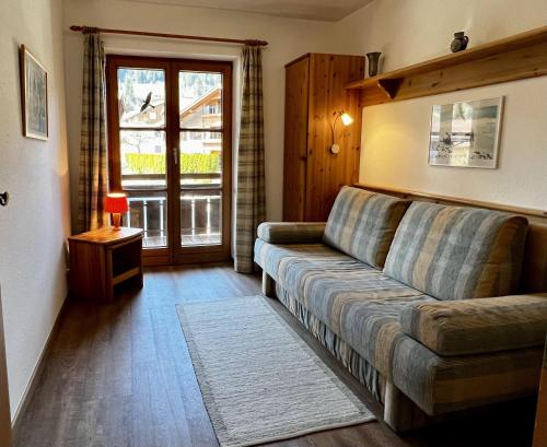 a living room with a couch and a window at Landhaus Bergidyll - Ferienwohnung Kapellenblick in Bolsterlang