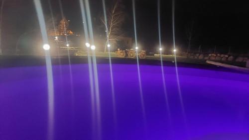 uma vista para uma piscina à noite com luzes em Domek nad Czerwienią em Przesieka