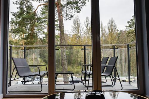 a balcony with chairs and a table and a window at Apartament Leśny No 64 nad Zalewem JACUZZI, KOMINEK z Garażem w cenie in Kielce