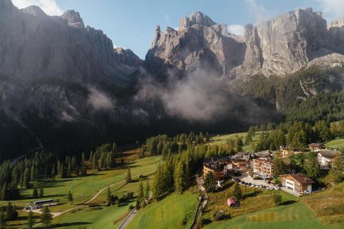 a village in a valley in the mountains at Kolfuschgerhof Mountain Resort in Colfosco