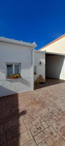een wit huis met een patio en een gebouw bij Casa rural La Golondrina in Villarta de San Juan