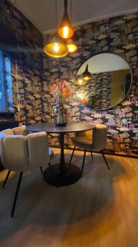 a dining room with a table and chairs and a mirror at Cosy Aquarium for a couple or friends in Groningen