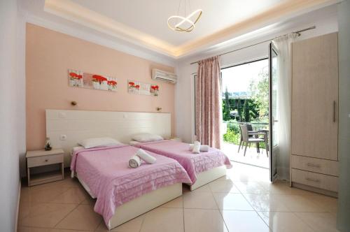 una camera da letto con un letto rosa e un balcone di Dolphin Apartments a Paleokastritsa