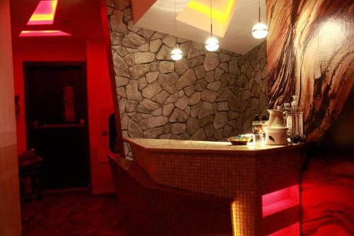 uma casa de banho com uma parede de pedra e um lavatório em Orchid Hotel no Dubai