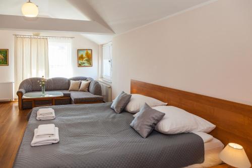 ein Schlafzimmer mit einem großen Bett und einem Sofa in der Unterkunft Villa MB in Augustów