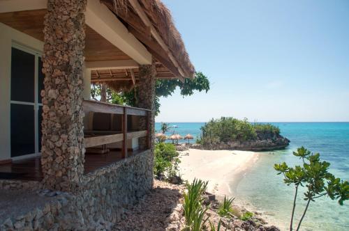 マラパスクア島にあるテパニー ビーチ リゾートの海の景色を望むビーチの家
