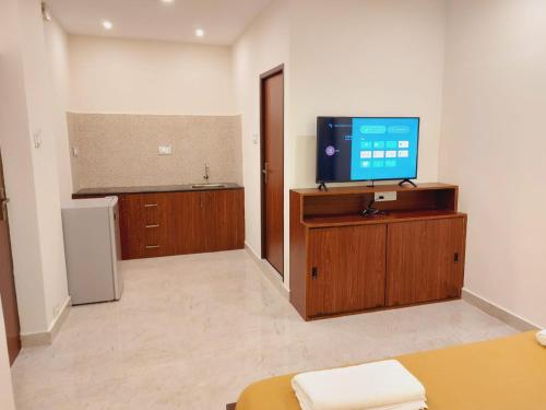 a living room with a tv on a wooden entertainment center at Chippy Residency in Chennai
