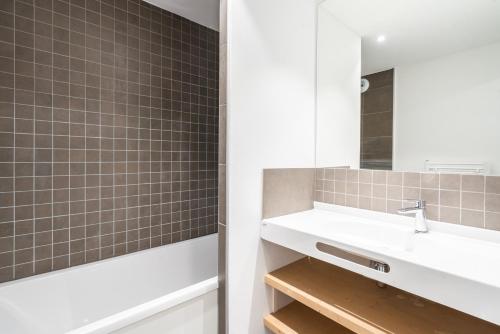 a bathroom with a sink and a mirror at Vacancéole - Les Ecrins d'Auris in Auris