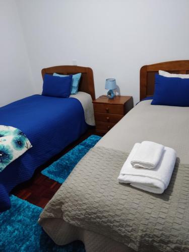 a bedroom with two beds with blue pillows at Apartamento a 2 minutos do santuário de Fátima in Fátima