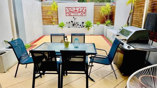 a table and chairs on a patio with a grill at Melbourne Inner City Holiday Home Near CBD & Flemington in Melbourne