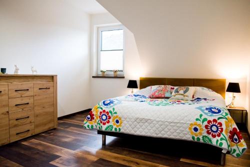 a bedroom with a bed and a dresser and a window at Apartamenty Długa in Nowy Targ