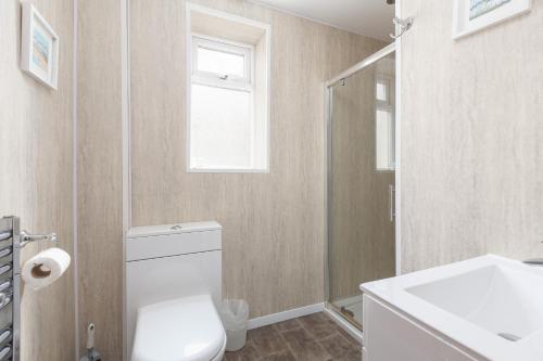 a bathroom with a toilet and a sink and a window at Beachcliffe Lodge Apartments in Blackpool