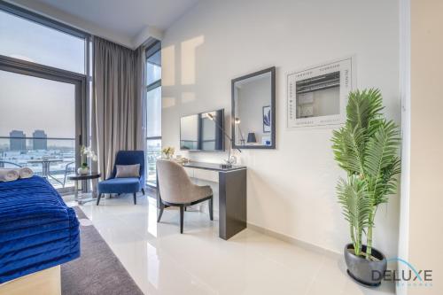a bedroom with a bed and a desk and a chair at Sunlit Studio at Golf Promenade 2A DAMAC Hills By Deluxe Holiday Homes in Dubai